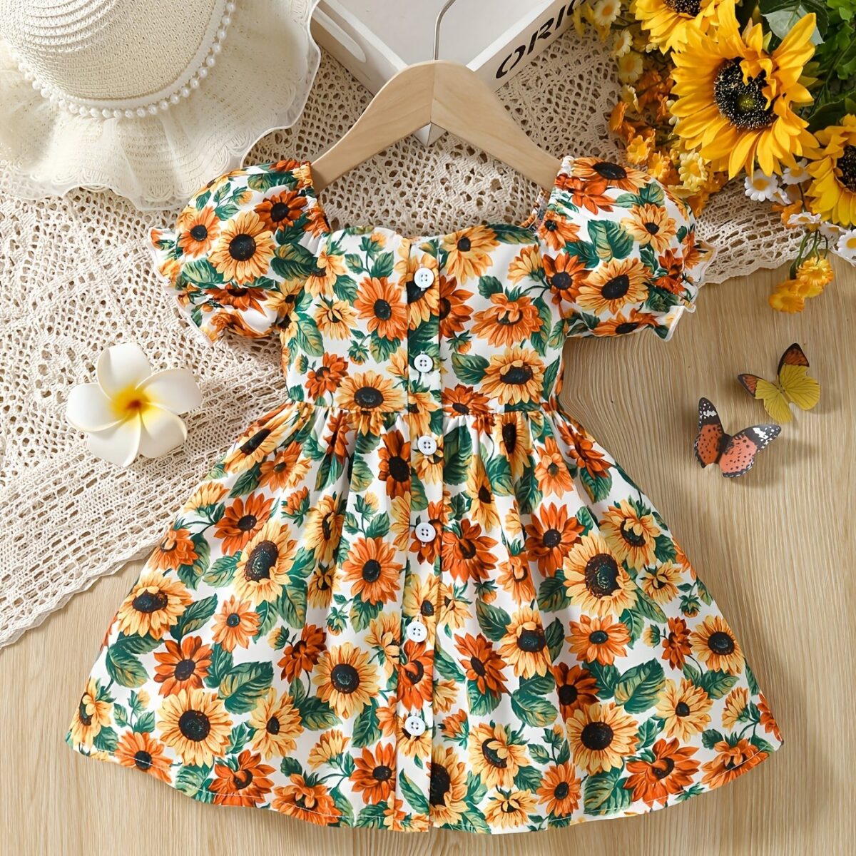 Baby girl wearing an adorable sunflower floral print dress perfect for summer