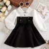Adorable baby girl wearing a Petite Darling Color Block Dress perfect for birthdays or back to school photos The dress features a vibrant color block design