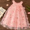 Adorable little girl twirling in a beautiful rosebud garden floral print dress perfect for weddings or a casual day out