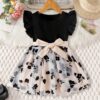 Adorable little girl twirling in a vibrant Summer Bloom floral print dress from Newness perfect for summer